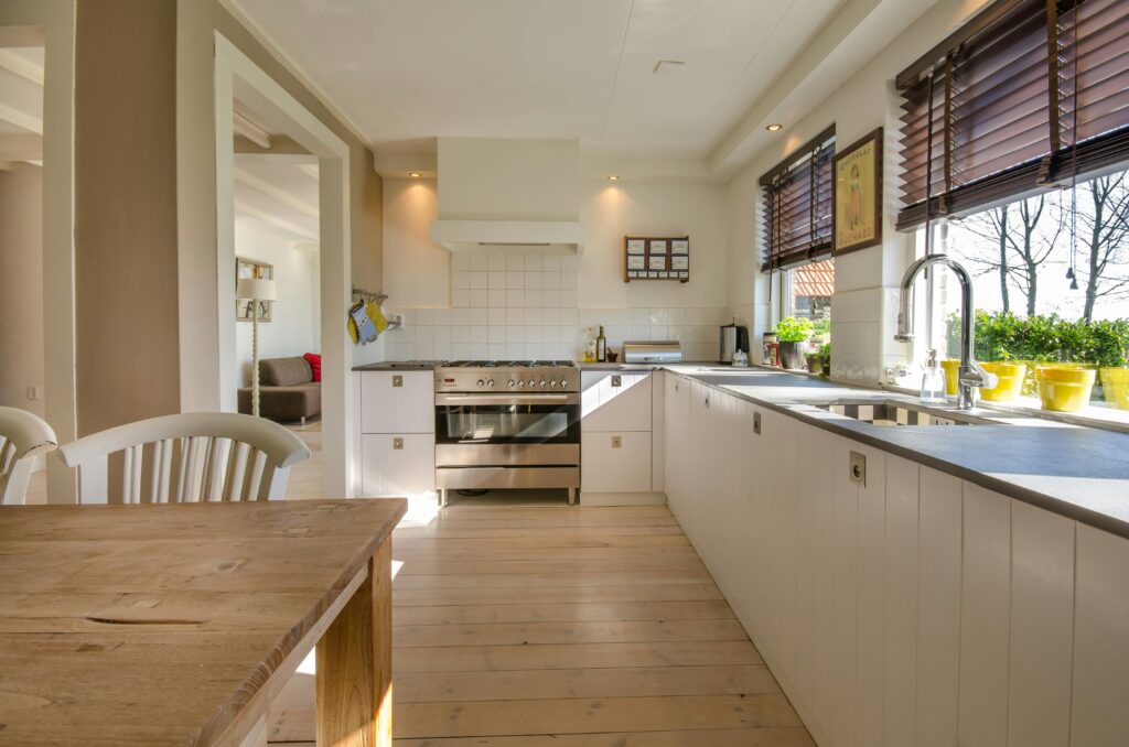 Bright kitchen interior featuring wooden flooring, sleek cabinets, and natural sunlight.